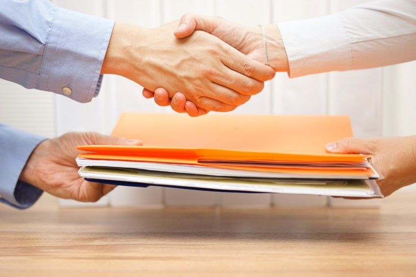 entrepreneur shaking hands with his accuntant after passing documenation and invoices